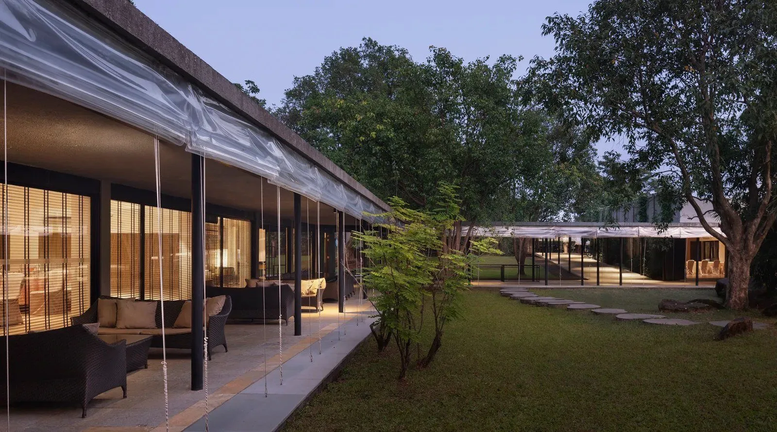 Dharana at Shillim — the low-slung contemporary pavilions set among trees at dusk