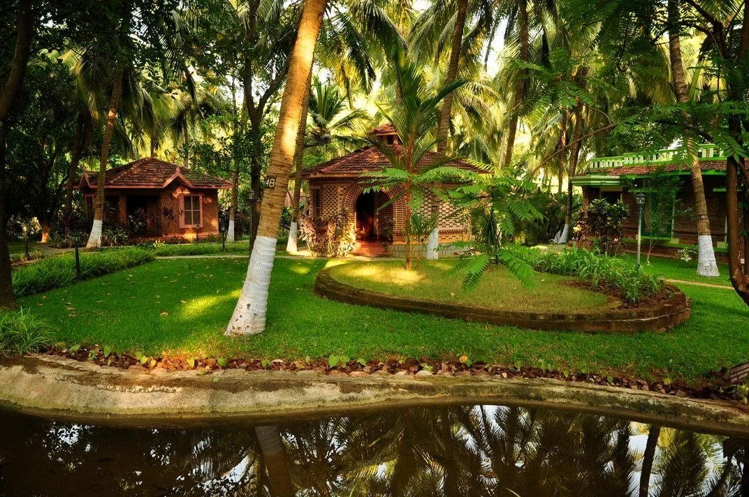 Kairali — The Ayurvedic Healing Village — traditional brick cottages set among coconut palms and gardens, with a still water canal, Palakkad, Kerala