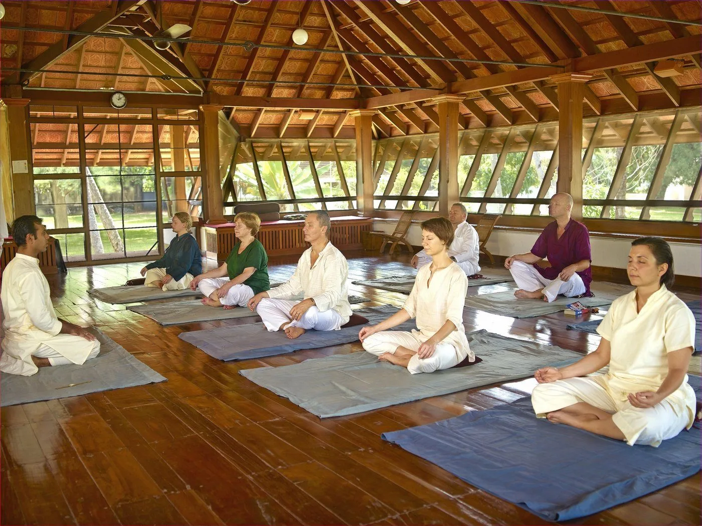 Kalari Kovilakom — a group meditation session inside the traditional Kerala-roofed hall