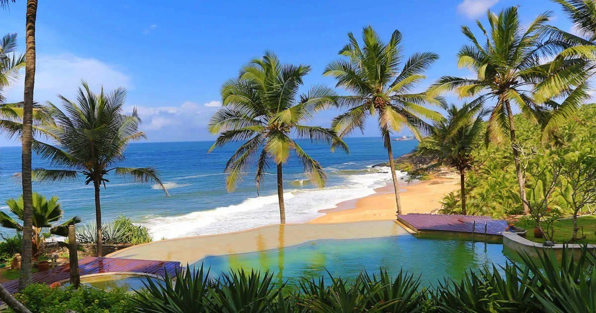 Niraamaya Retreats, Surya Samudra — the clifftop infinity pool overlooking the beach cove at Kovalam
